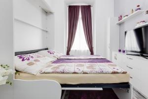 a small bedroom with a bed and a flat screen tv at Apartment Thunovská 10 in Prague