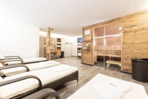 una camera con tre letti in una stanza con pareti in legno di Appartements AUSZEIT with private SPA a Embach