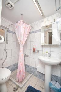a bathroom with a pink shower curtain and a sink at Ntanis 43 House in Khalidhiáta
