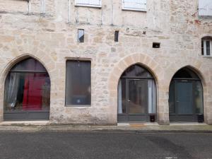 three arched windows on a stone building at Consulat Figeac in Figeac