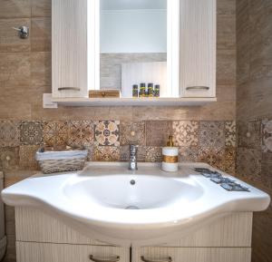 een badkamer met een witte wastafel en een spiegel bij Iro City and Beach Boutique Homes in Chania