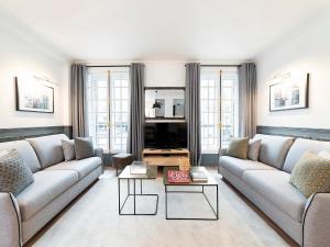 a living room with two couches and a tv at LivinParis - Luxury 2 Bedrooms Centre Pompidou in Paris