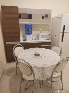 a kitchen with a table with chairs and a microwave at Acomodação corporativa: casa residencial recém-construída in Itatiba