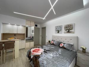 a bedroom with a large bed and a kitchen at Lasadu Studio in Casa Al Mare, 2 min to Beach in Bečići