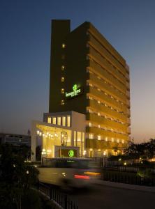 un edificio con una señal verde en él por la noche en Lemon Tree Hotel Hinjewadi Pune, en Pune