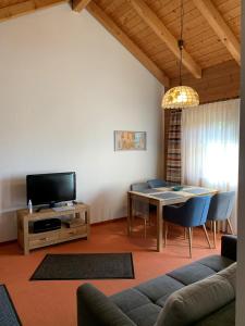 a living room with a table and a tv at Ferienwohnung Landsberg am Lech in Landsberg am Lech