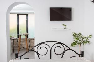 - une chambre avec un lit et une télévision murale dans l'établissement Vinea Suites, à Trogir