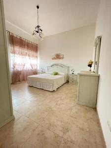 um quarto com uma cama branca e piso em azulejo em Masseria Paglieroni em Martina Franca
