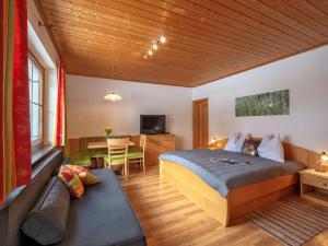 um quarto com uma cama e um sofá num quarto em Landhaus Schwaiger em Bad Hofgastein