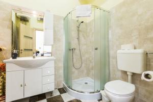uma casa de banho com um chuveiro, um WC e um lavatório. em Lady of Health Apartments em Zadar