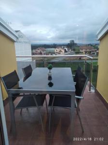 una mesa y sillas en un balcón con vistas en Mirada del camino en Melide