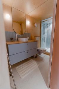a bathroom with a sink and a toilet at Au fond du jardin in Profondeville