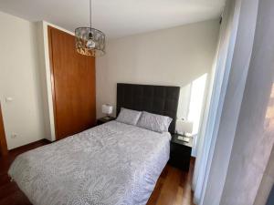 a bedroom with a bed and a chandelier at Apartamento tranquilo Vielha Centro con Parking Gratuito in Vielha