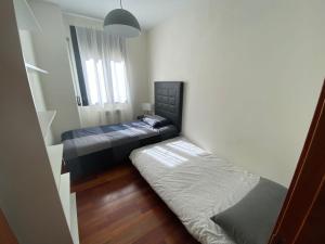 Habitación pequeña con 2 camas y ventana en Apartamento tranquilo Vielha Centro con Parking Gratuito, en Vielha