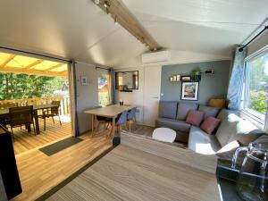 uma sala de estar e sala de jantar de uma pequena casa em NEW Jungle Lake - Clim - WIFI - Draps & serviettes - BBQ - 10' des plages em Lattes