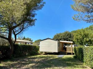 une petite maison blanche dans une cour avec un arbre dans l'établissement NEW Jungle Lake - Clim - WIFI - Draps & serviettes - BBQ - 10' des plages, à Lattes