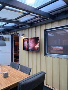 una grande TV a schermo piatto a parete con tavolo di S-CHALET Camping mit Comfort im Schwarzwald a Steinach