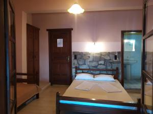 a bedroom with a bed and a stone wall at Triple studio room with the most beatifull view in Mylopotamos in Tsagarada