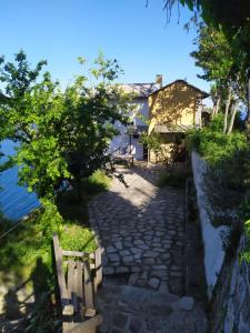a stone walkway next to a house and the water at Triple studio room with the most beatifull view in Mylopotamos in Tsagarada