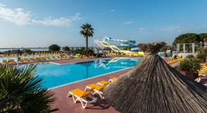 una grande piscina con sedie e un resort di NEW Jungle Lake - Clim - WIFI - Draps & serviettes - BBQ - 10' des plages a Lattes