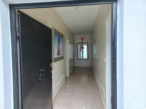 einen Flur mit einer Tür, die zu einem Flur mit einem Hallwayngth führt in der Unterkunft Turnbull's Apart Hotel in Consuelo