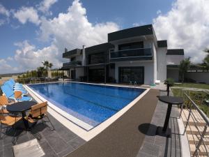 une maison avec une piscine en face de celle-ci dans l'établissement DKD DELÜXE, à Izmir