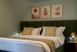 a bedroom with a large bed with a green headboard at Grand Opera Hotel in Kutaisi