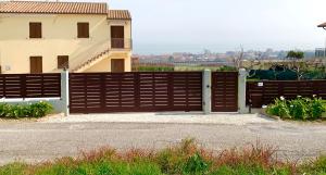 ein Holztor vor einem Haus in der Unterkunft Casa Vacanze con Vista Mare e Giardino - Amanecer in Marzocca di Senigallia