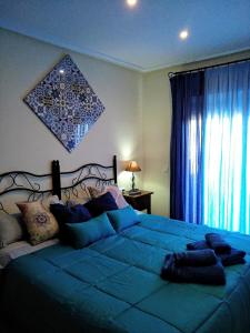 Un dormitorio con una gran cama azul y una ventana en HOME STAR IV con vistas, en Vera