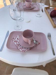 un plato rosa con una taza sobre una mesa en HACIENDA LA MACARENA DE SEVILLA, en Cantillana