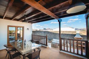 taras ze stołem i krzesłami na balkonie w obiekcie Villa Vista Rey - 6 Bedroom - Heated Pool - Amazing Views - Pool Table - Vista Lobos - Playa Blanca w mieście Playa Blanca