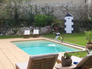 a small swimming pool with two chairs and a table at Casa frente a los Bufones de Pria in Llames de Pría