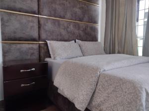 a bedroom with a bed with a headboard at Mkamiti Villa - Airport Hotel in Dar es Salaam