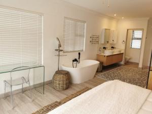 a large bathroom with a tub and a sink at Nearby Herolds Bay Self-Catering Guest House in Herolds Bay +38 photos