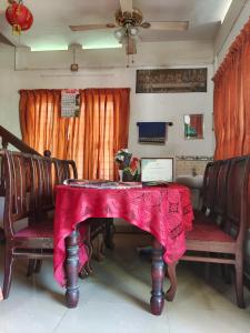 a dining room table with a red table cloth on it at Achayans Homestay Mararikulam in Mararikulam