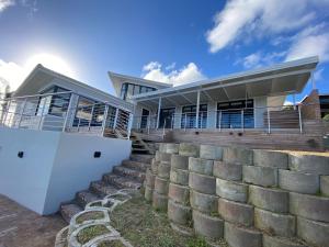 a house with a retaining wall and stairs at Nearby Herolds Bay Self-Catering Guest House in Herolds Bay