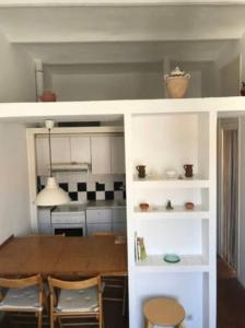 a kitchen with a table and a dining room at Apartamento Luminoso y Acogedor Port de la Selva in Port de la Selva