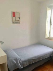 a bedroom with a bed in a white room at Apartamento Luminoso y Acogedor Port de la Selva in Port de la Selva