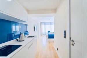 uma cozinha com armários azuis e brancos e uma sala de estar em BEST HOUSE ORBI CITY em Batumi