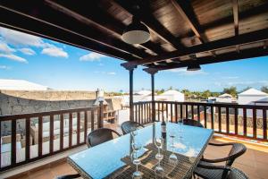 taras ze stołem i krzesłami na balkonie w obiekcie Villa Vista Rey - 6 Bedroom - Heated Pool - Amazing Views - Pool Table - Vista Lobos - Playa Blanca w mieście Playa Blanca