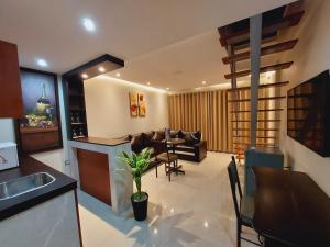 Hotel Puma'r Tacna في تاكنا: مطبخ وغرفة معيشة مع أريكة وطاولة