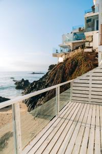 a boardwalk leading to a beach with a building at Maressenza Night Spa in Viña del Mar
