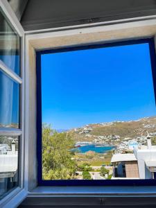 a window with a view of a bay at Orizon Tagoo Mykonos in Mikonos