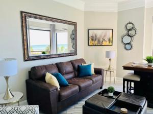 sala de estar con sofá marrón y espejo en 210 Sea Gem Oceanfront Pet Friendly Indoor Pools, en Myrtle Beach