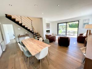 een woonkamer met een houten tafel en stoelen bij Magnifique Villa en bord de mer à Fort-Bloqué in Ploemeur