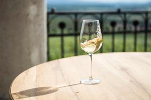 a glass of white wine sitting on a table at Kincsem Kastély in Tolcsva
