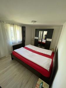a bedroom with a large bed with a red blanket at Apartman Magdalena in Banja Koviljača
