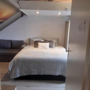 a bedroom with a bed and a couch at Studio vlak bij het strand in Petten