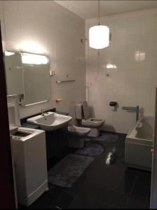 uma casa de banho com 2 WC, um lavatório e uma banheira em Appartamento in villa sulle colline di Torino em Turim