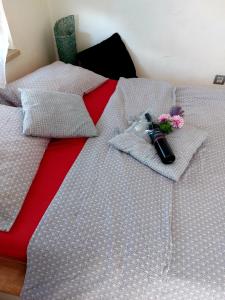 a bed with a red and white comforter with a flower on it at Studio Concept Apartment in Zagreb